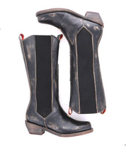 A pair of Clarisse black distressed leather cowboy boots by Bed|Stü, featuring pull tabs, elastic side panels, and stacked western heels, displayed side by side in a classic mid-calf tall boot silhouette.