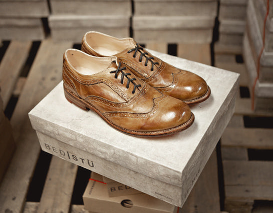Pair of tan leather wingtip lace-up shoes displayed on a BED|STU shoe box.