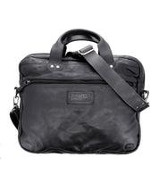 Introducing Conclusion by Bed|Stü—a black messenger bag made from vegetable-tanned leather. Designed with two handles, a front zip pocket, and an adjustable shoulder strap, this elegant laptop bag features a dedicated laptop compartment, showcased against a white background.