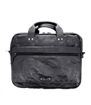 The Bed|Stü Conclusion is a black leather briefcase featuring top handles, a dedicated laptop compartment, a front zippered pocket, and adorned with a small rectangular logo at the bottom center.