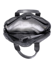 The Bed|Stü Conclusion handbag is shown open from above, displaying its empty interior made from vegetable-tanned black leather. Multiple compartments, a secure zipper closure, and a dedicated laptop section are clearly visible.