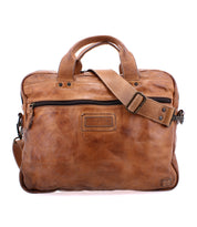 Introducing the Bed|Stü Conclusion: a brown leather messenger bag featuring two short handles, an adjustable shoulder strap, visible front stitching, and a convenient front zipper pocket. Crafted from premium vegetable-tanned leather, the Conclusion also offers a dedicated laptop section for enhanced convenience and organization.