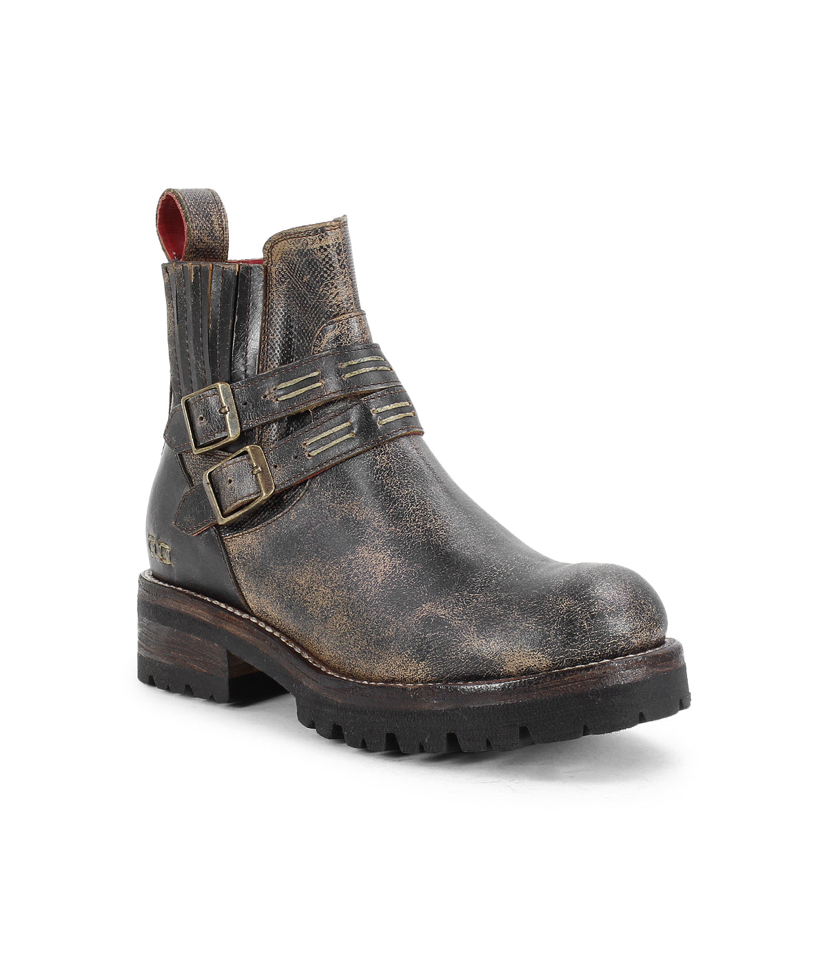 The Daring ankle boots by Bed|Stü feature distressed brown leather, dual decorative buckles, ribbed side details, a signature red pull tab, and a thick treaded sole for classic rugged style with modern flair.