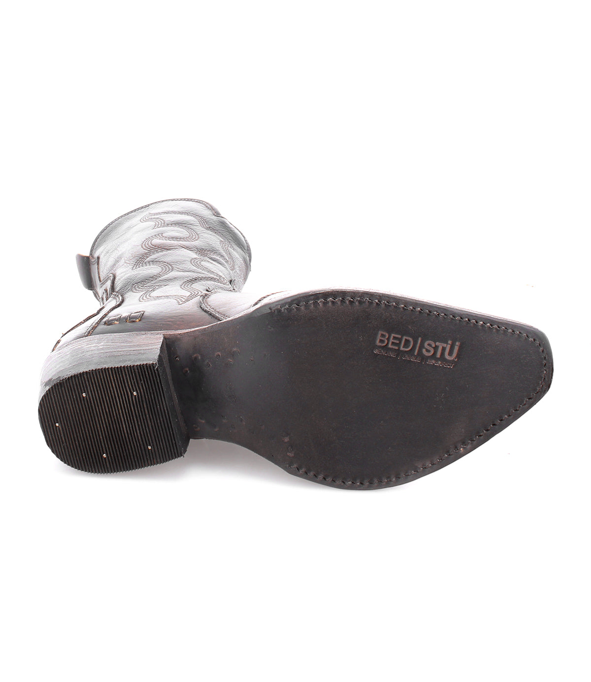 A single Deuce Western boot by Bed|Stü lies on its side, displaying the vegetable-tanned leather sole with detailed stitching and the "Bed|Stü" logo stamped near the arch.
