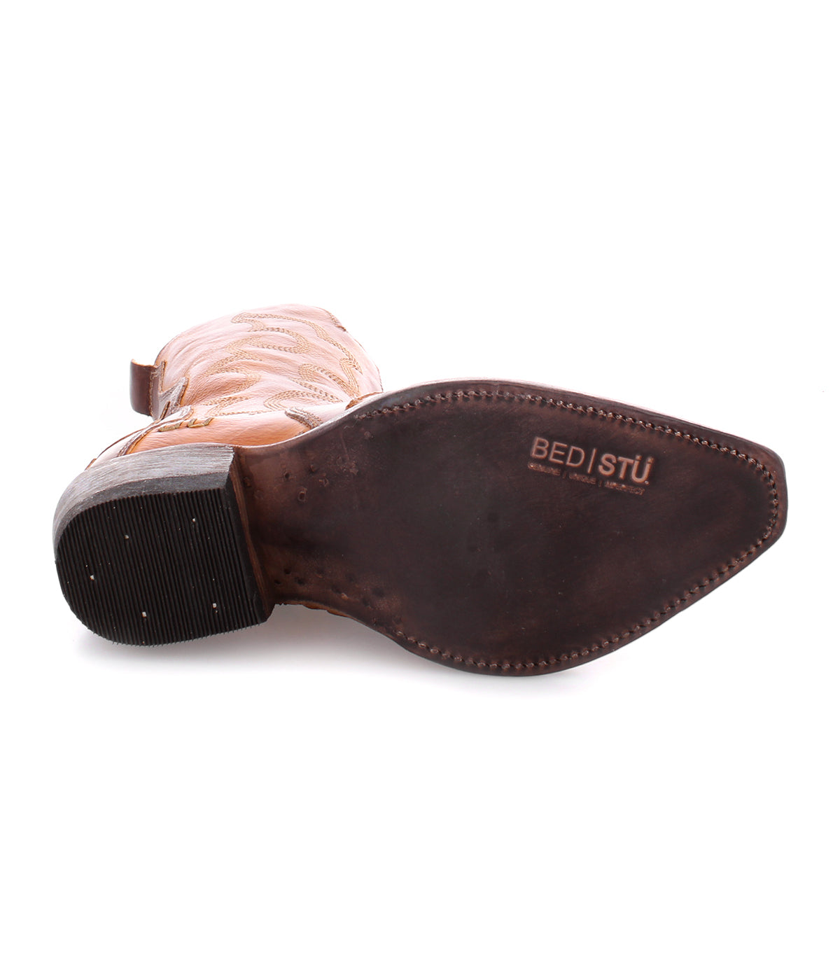 A single Deuce cowboy boot in tan, made from vegetable-tanned leather, is displayed sole-up to reveal the "Bed|Stü" brand stamped on its dark brown leather outsole.