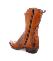 The Bed|Stü Deuce, a brown leather cowboy boot featuring detailed stitching, a side zipper, and a low heel, is shown on a white background.