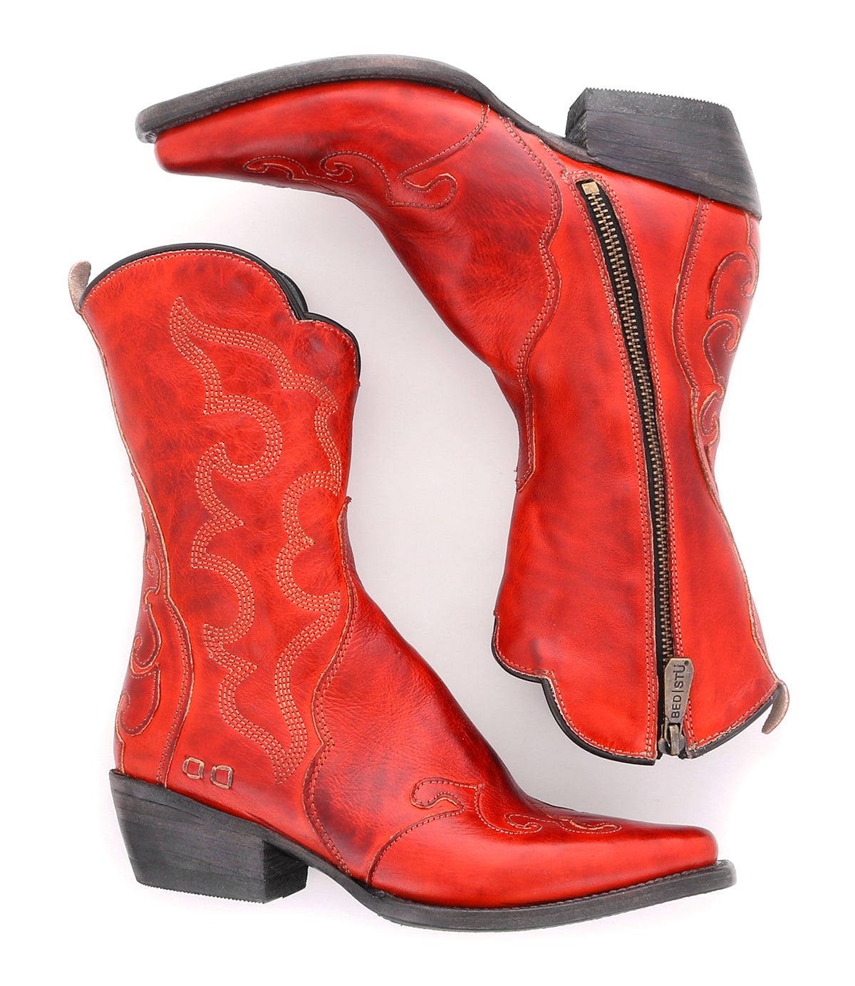 A pair of Bed|Stü Deuce boots in red vegetable-tanned leather, featuring detailed stitching, black heels, and side zippers, shown from the side and top views.