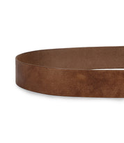 The Bed|Stü Dreampath belt is displayed in a close-up view, partially coiled on a white background. The plain brown genuine leather strap features an octagon metal buckle, showcasing its understated yet distinctive design.