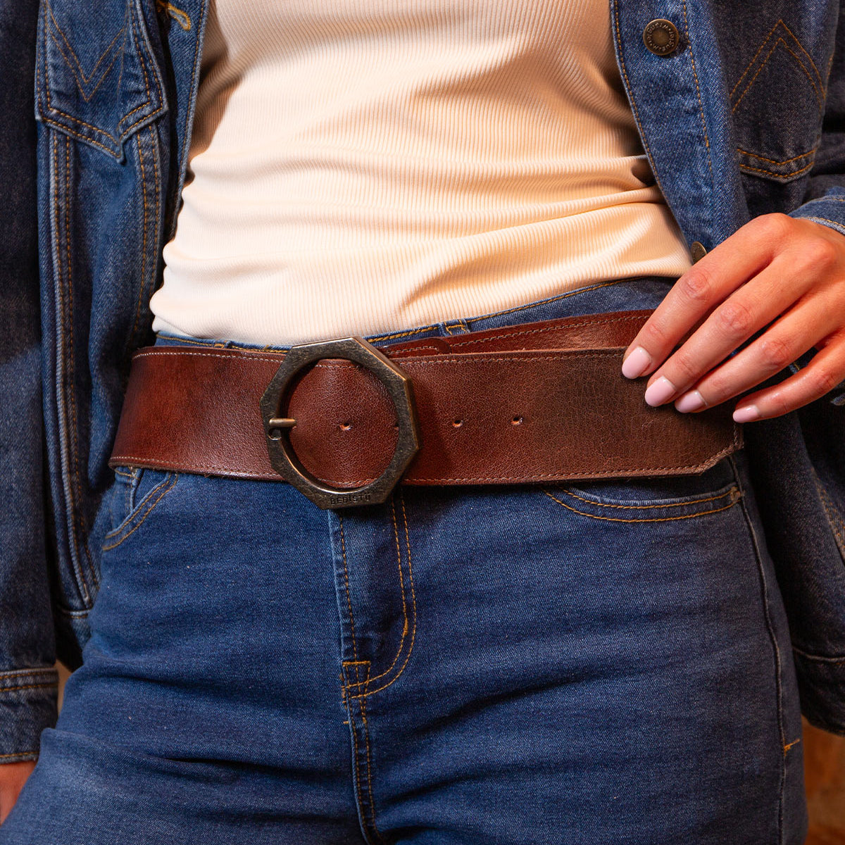 Person wearing a cream ribbed shirt, blue denim jacket, and jeans accessorized with the BED|STÜ Dreampath genuine leather belt featuring a large octagon metal buckle.