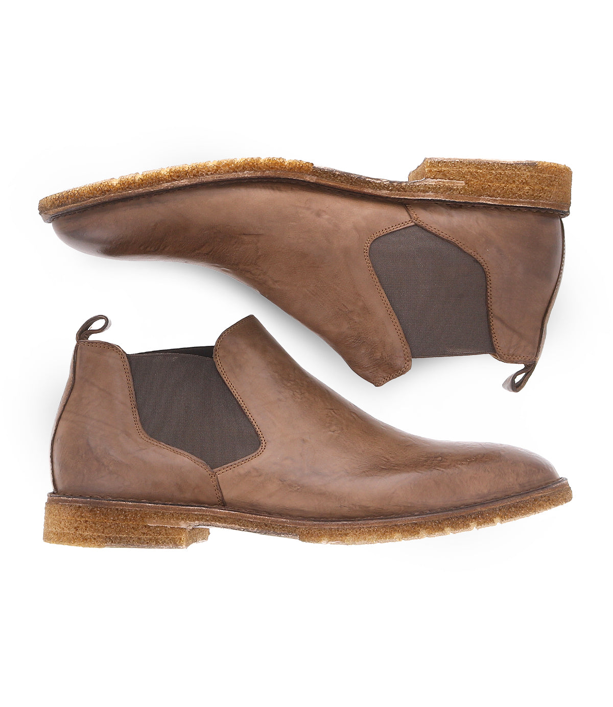 Introducing the Bed|Stü Elude — a pair of brown leather Chelsea boots featuring elastic side panels and crepe soles, displayed from the side and bottom. These slip-on men's boots blend comfort with sophistication, offering a timeless addition to any wardrobe.