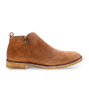 Side view of the Evade men's suede boot by Bed|Stü in brown, handcrafted in Italy, featuring a zipper closure, a pull tab at the back, and a low, textured rubber sole.