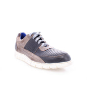 The Bed|Stü Fairman is a single men's sneaker showcasing a three-tone leather upper in black and gray, perforated sides, gray laces, a lightweight sole, and a blue inner lining, all set against a white background.