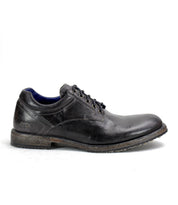 A single Bed|Stü Fierce black washed leather derby lace-up dress shoe with a worn sole, shown in profile on a white background.