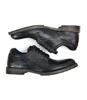 A pair of Bed|Stü Fierce black washed leather derby dress shoes is shown from the side, featuring visible creases and scuff marks on the surface.