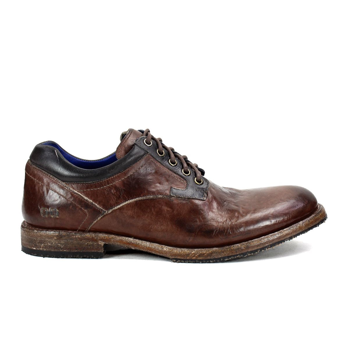 The Bed|Stü Fierce shoe is a brown washed leather derby lace-up dress shoe featuring a worn finish, low wooden sole, and black collar detail, displayed in side profile against a white background.