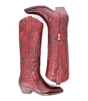 Step out in style with the Finito boots from Bed|Stü—a tall, red leather cowboy design featuring decorative stitching, a classic western silhouette, side zipper, and medium heel. Displayed in both side and bottom views against a white background.
