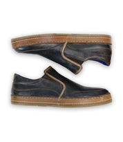 A pair of Bed|Stü Freestyle black leather slip-on sneakers with brown soles, leather trim, and visible stitching, displayed side by side on a white background.