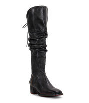 The Leilani by Bed|Stü is a black, knee-high leather boot featuring a low block heel, a slightly slouched shaft with elegant ruching, stitched detailing, and a pull string at the top.
