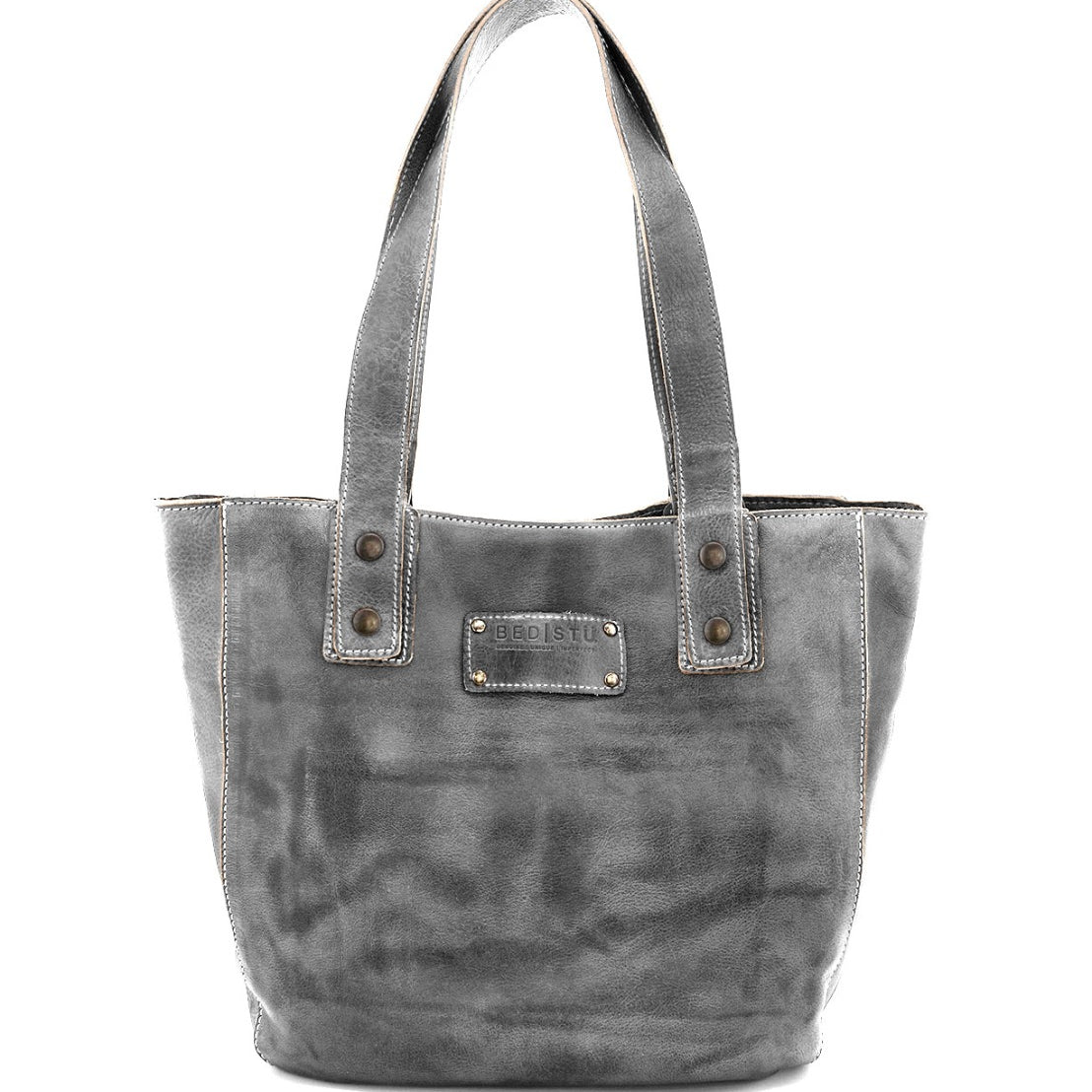 Introducing the Gaviota by Bed|Stü—a gray leather tote bag featuring dual handles, prominent stitching, and a rectangular metal logo plate on the front embossed with "Bed|Stü." This distinctive accessory effortlessly blends timeless style with eye-catching details for a chic, standout look.