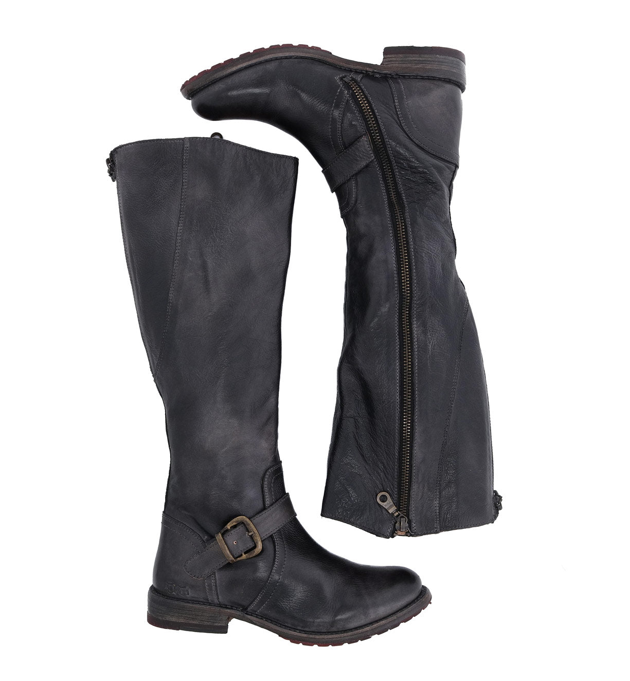 A pair of Glaye tall leather boots by Bed|Stü, featuring side zippers and vintage buckle details inspired by classic equestrian style, displayed with one boot upright and the other lying on its side against a white background.