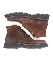 A pair of Bed|Stü Goer rugged brown oiled suede leather boots with black lug soles, stacked heel to toe and viewed from the side.