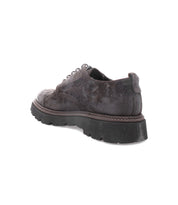 The Bed|Stü Grant is a single dark brown suede leather derby lace-up shoe featuring a thick black tread sole, displayed at an angled rear view against a white background.