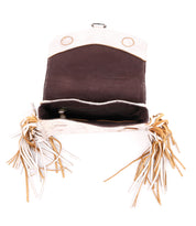 Open Bed|Stü Hidden suede bag viewed from above, featuring a soft leather finish, structured silhouette, brown interior, fringed sides in white and tan, and a flap with two snap closures.