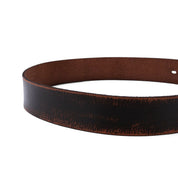 A close-up of the Bed|Stü Hobo belt highlights its sturdy brown leather strap with a distressed texture, featuring one hole visible on the right edge.