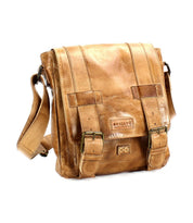 Hue by Bed|Stü is a light brown leather messenger bag featuring two front buckles, an adjustable crossbody strap, and visible stitching on the flap and sides—perfect for carrying your essentials from work to weekend.