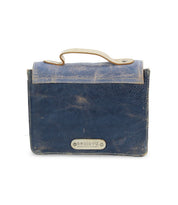 A compact, rectangular blue leather mini purse called Improv by Bed|Stü, featuring a top handle and a metal label on the front.