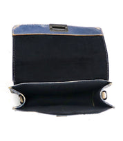 The Improv handbag by Bed|Stü is displayed open and empty against a white background, showcasing its blue fabric exterior, black interior, and a convenient top handle for easy carrying.