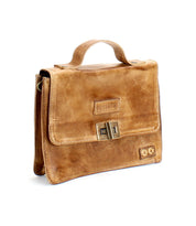 The Improv satchel by Bed|Stü—a light brown leather bag featuring a top handle, front flap, and metal clasp—is displayed against a white background.