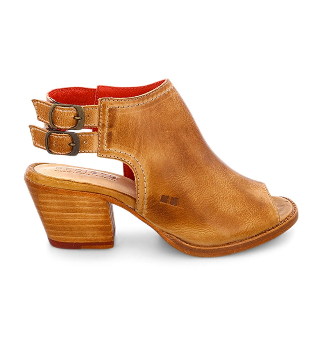Step out in style with the Ireni peep-toe heeled sandal from Bed|Stü, crafted in brown leather with two side buckles, a red lining, stacked heel, and open back. Designed for all-day comfort with its cushioned footbed, this everyday essential is shown on a white background.
