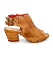 Step out in style with the Ireni peep-toe heeled sandal from Bed|Stü, crafted in brown leather with two side buckles, a red lining, stacked heel, and open back. Designed for all-day comfort with its cushioned footbed, this everyday essential is shown on a white background.