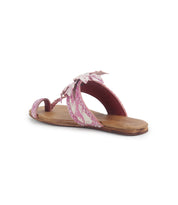 The Isobel sandal by Bed|Stü is a single flat design with a wooden sole, pink and white patterned straps highlighted by a delicate braided strap and a charming bow detail, shown from a rear side angle against a white background—perfect for effortless summer looks.