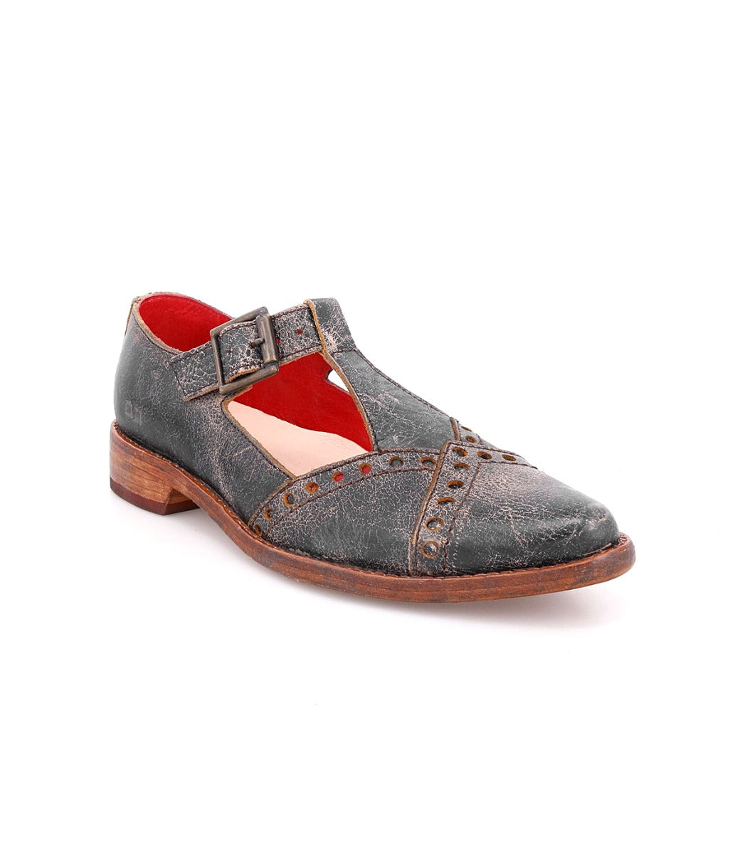 The Jenny by Bed|Stü is a single dark grey vintage-style leather shoe featuring a low heel, buckle strap, red interior lining, cushioned insole for added comfort, and decorative perforations on the toe and sides.