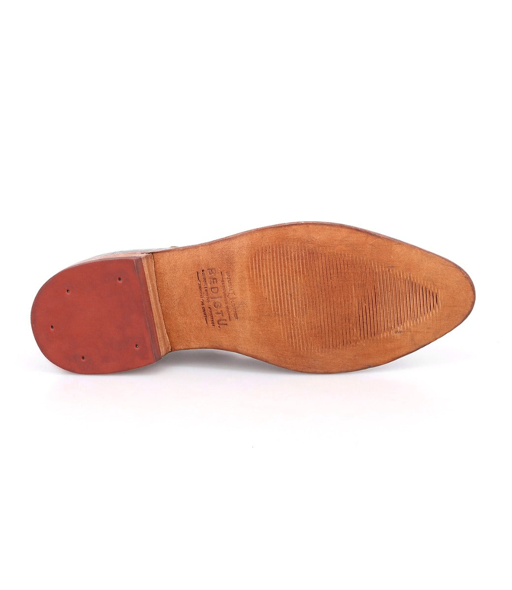 The underside of the Bed|Stü Jenny brown leather dress shoe reveals a slightly worn sole with visible stitching and textured grip marks, along with manufacturer details near the heel—subtle indicators of its quality craftsmanship. Designed with both comfort and timeless style in mind, this classic silhouette features a cushioned insole for added support throughout your day.