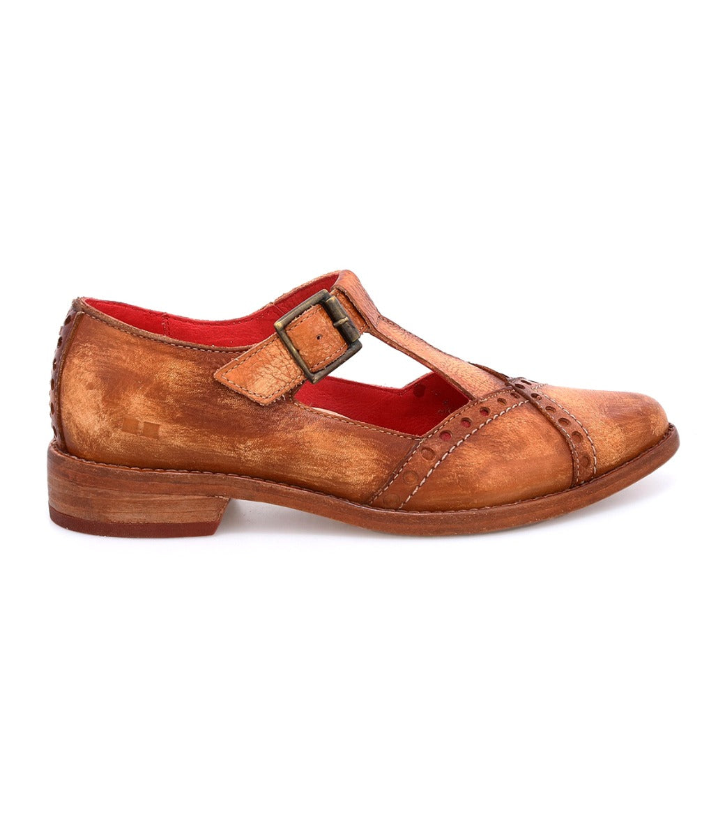 The Jenny by Bed|Stü is shown in a side view as a single brown leather T-strap shoe with a low heel, visible buckle, cushioned insole for added comfort, and a red interior.