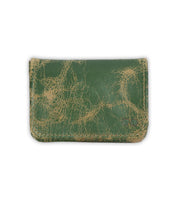 A distressed green leather card wallet, the Jeor by Bed|Stü, features visible cracks and scuffs and includes dedicated credit card slots, displayed on a plain white background.