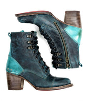 The Judgement boots by Bed|Stü are ankle-high, lace-up leather boots featuring a cap toe, teal and black leather accents, wooden block heels, side zippers, and metal eyelets.