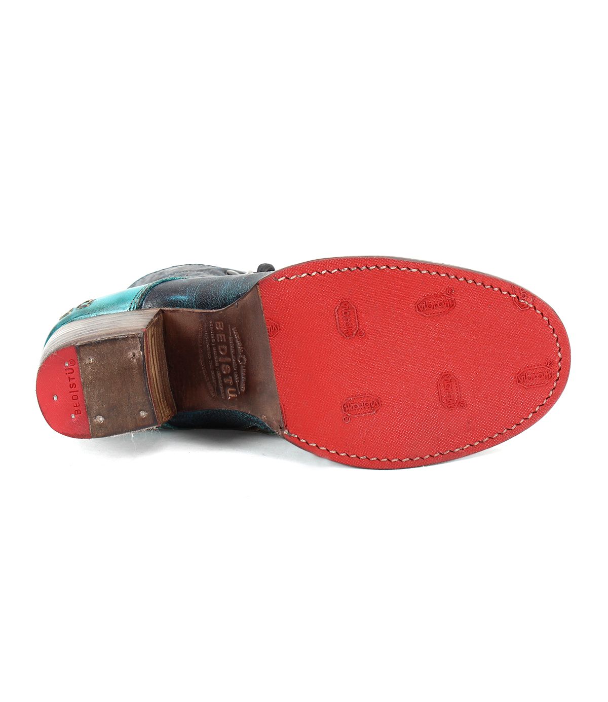 The Bed|Stü Judgement cap toe dress shoe is displayed from the bottom, showcasing its distinctive red textured sole with small imprints and a stacked leather heel.