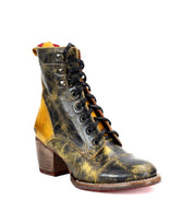 The Bed|Stü Judgement is a single cap toe leather lace-up boot in distressed black and yellow, featuring a striking wooden block heel, shown on a white background.