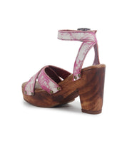 Introducing the Kalah by Bed|Stü: a pink strappy sandal with a high platform heel and adjustable ankle strap, featuring distinctive metal rivet accents and distressed, worn-in leather straps. The sustainably sourced wooden heel adds an eco-conscious element to this standout design.