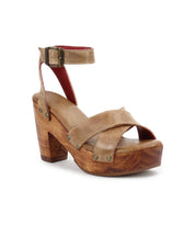 The Kalah sandal by Bed|Stü features tan leather with crossed front straps, a thick sustainably sourced wooden platform heel, and an adjustable ankle strap with buckle, shown on a white background.