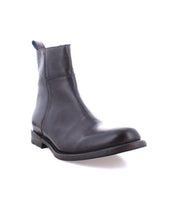 The Bed|Stü Kaldi is a classic black leather ankle boot featuring a low heel and pull tab, displayed against a white background.