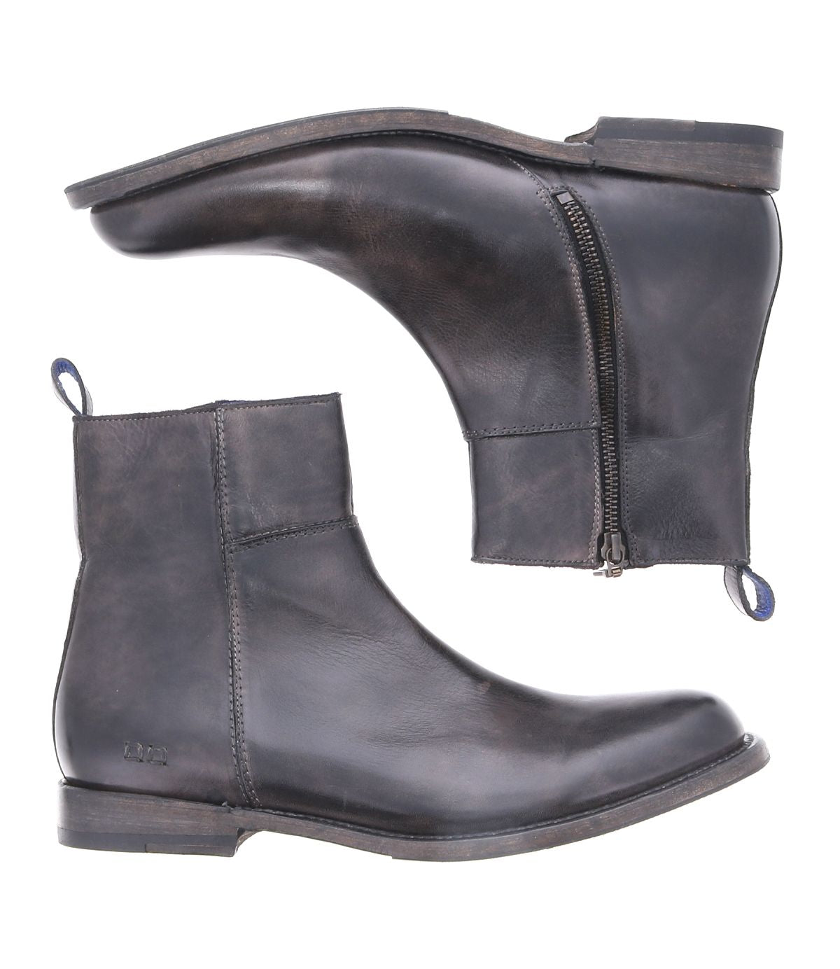 The Bed|Stü Kaldi is a pair of dark brown leather ankle boots featuring side zippers and pull tabs, displayed from the side and bottom against a white background; these classic boots effortlessly blend style with practicality.