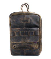 The Kamet backpack by Bed|Stü is crafted from distressed brown, vegetable-tanned leather and showcases a front pocket, stitched detailing, and a small top handle. It is photographed against a white background.
