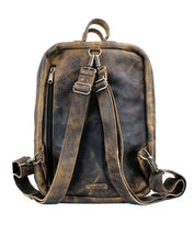 The Kamet backpack by Bed|Stü is a vintage-style brown leather bag, crafted from vegetable-tanned leather, shown from the back with adjustable shoulder straps, a top handle, and a vertical zip pocket.