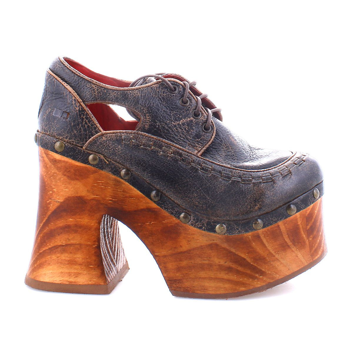 Experience the Bed|Stü Karaoke: a vintage-inspired platform shoe featuring a dark leather upper, decorative stitching, brass studs, lace-up detail, and a chunky sculpted wooden heel reminiscent of classic 70s style.