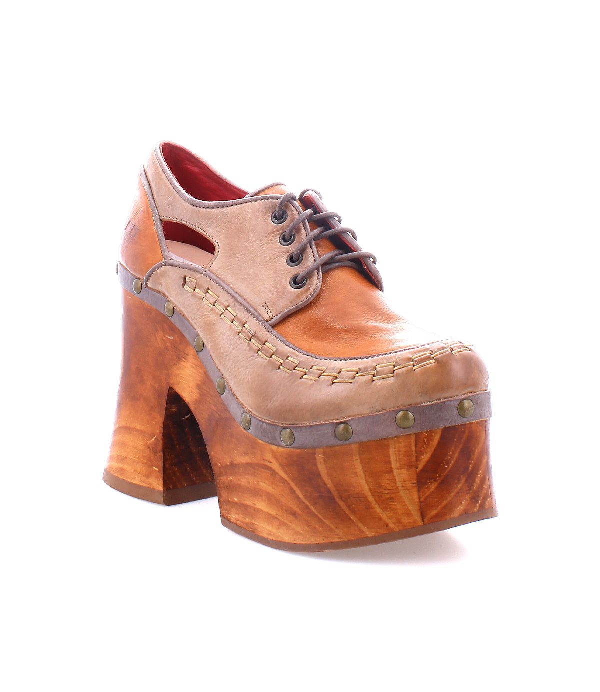 The Bed|Stü Karaoke is a brown leather lace-up platform shoe featuring cutout details, metal stud accents, a chunky wooden platform sole inspired by 70s style, and a lace-up front, displayed against a white background.